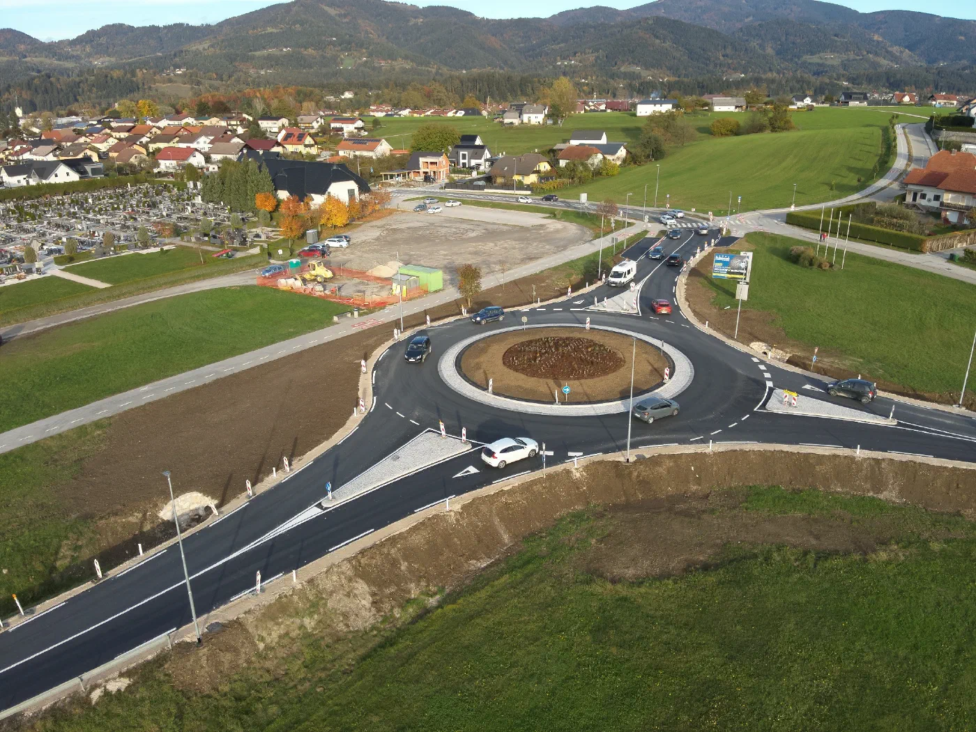 Obstoječe krožišče pri pokopališču Stari trg s tremi kraki in makadamskim parkiriščem.